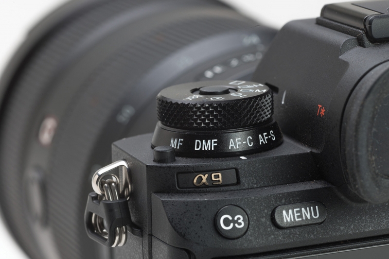 The lower ring of the combined drive and focus stack is used to select the focus mode, here set to continuous autofocus. The upper portion of the dial selects the frame rate.