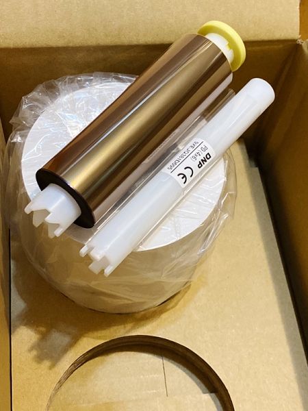 One of the two 4x6-inch DNP paper rolls that come two per box with its matching ribbon placed on top. As you can see, the rolls are protected well to help avoid damage.­