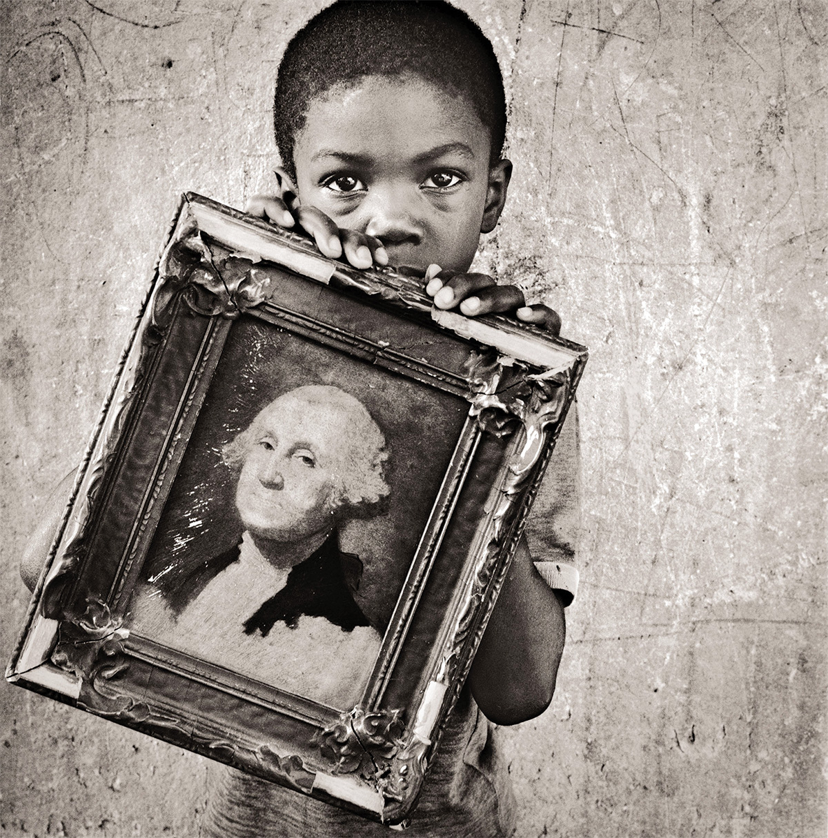 Boy holds a framed portrait of president George Washington