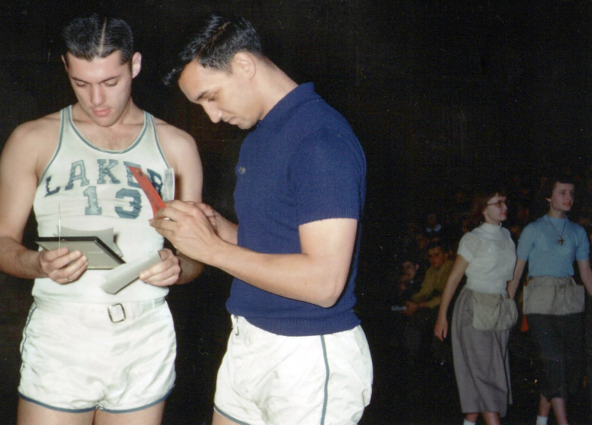 1952 Minneapolis Lakers basketball players Bud Grant and Bob Harrison confer with ushers in the background 