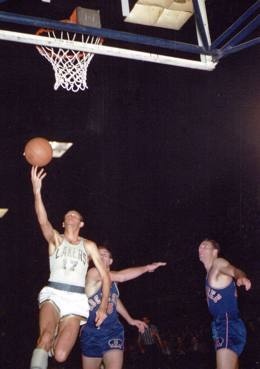 Basketball player Jim Pollard executes a layup while opposing players defend, circa 1952