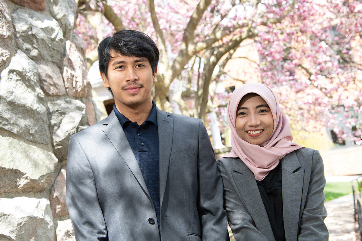 Portrait of a couple in front of trees with pink blossoms
