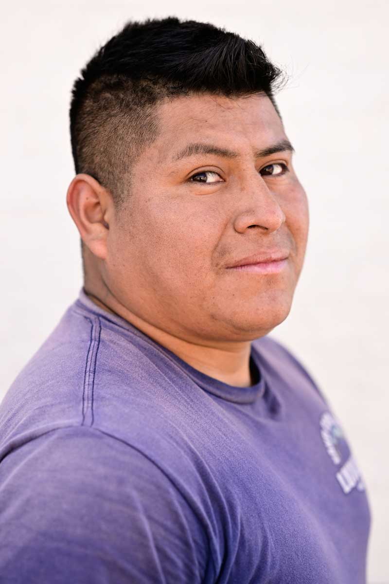 Three-quarter portrait of Hispanic man wearing a purple t-shirt