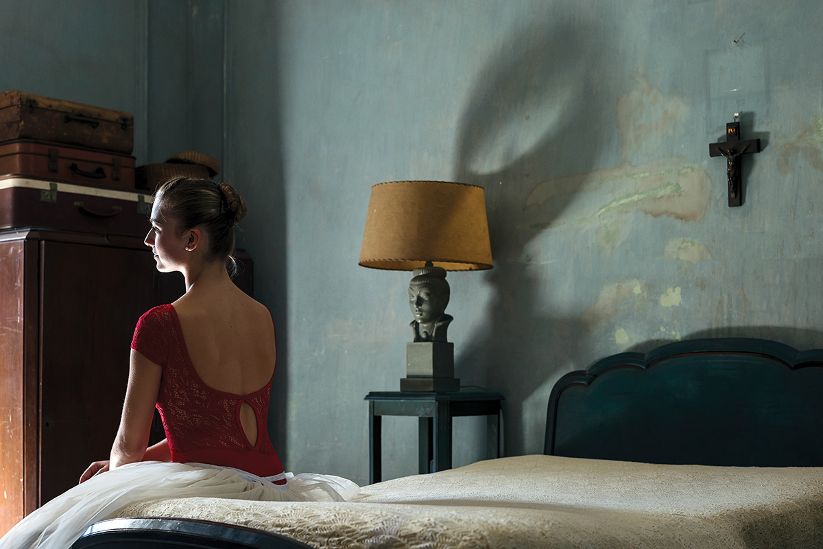 A photo of a woman sitting on the bed by Christopher Michel