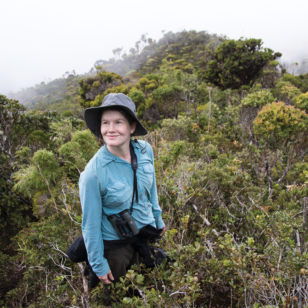 Photographer Gabby Salazar standing on a mountain peak