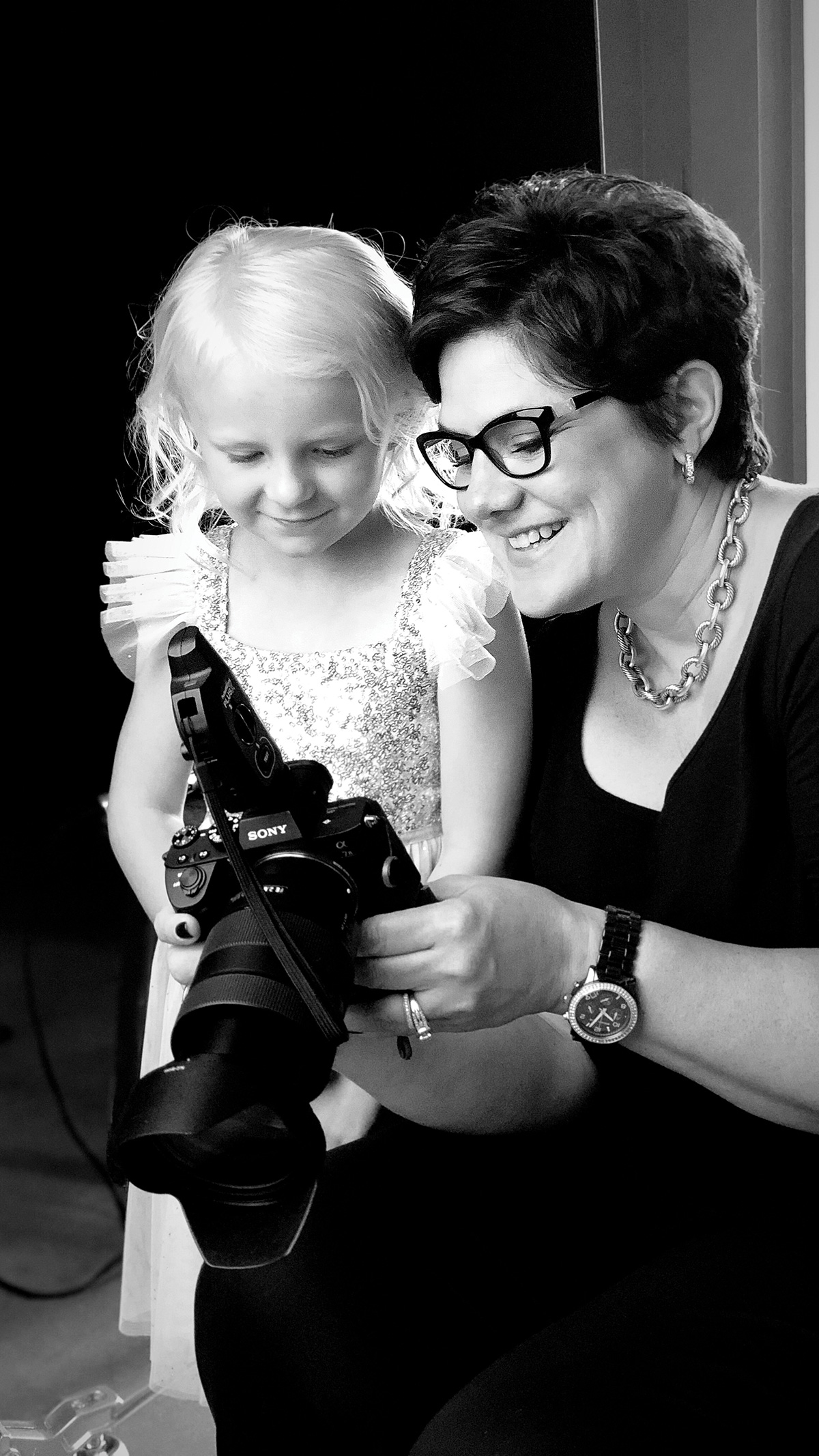 Photographer shows a child her picture on the digital back of her camera
