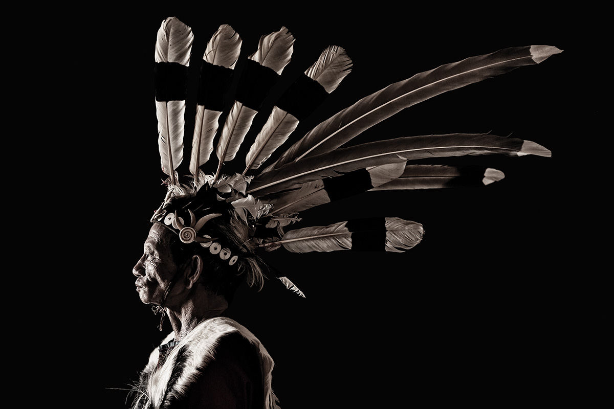 Profile of a man wearing a feathered headdress