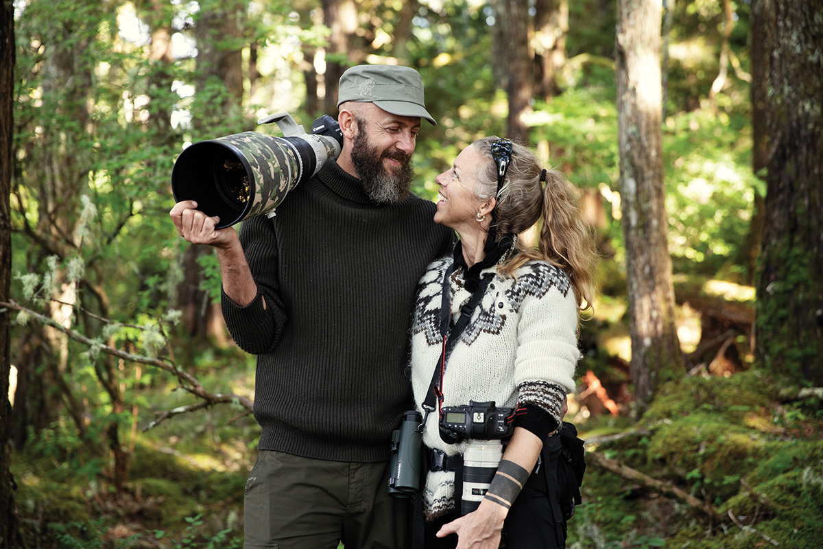 photographers Uri and Helle Golman standing ina forest holding their cameras