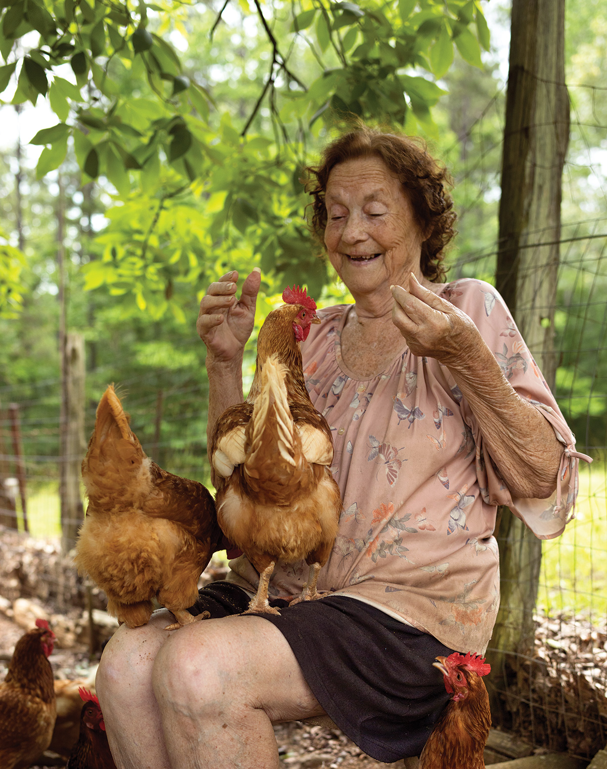 Seated woman with chickens on her lap