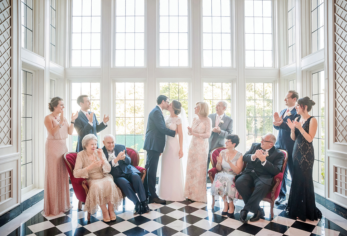 Family clapping as bride and groom kiss