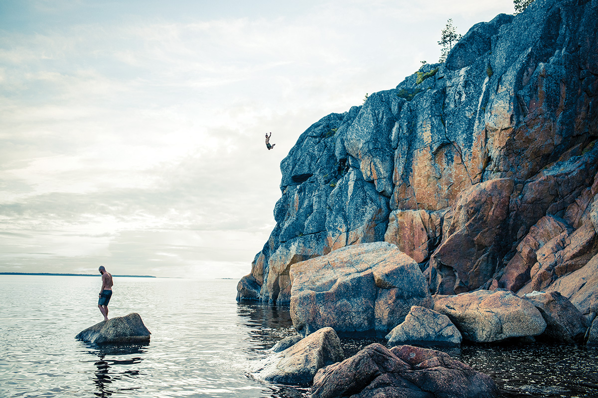 A person jumping from a cliff into the ocean
